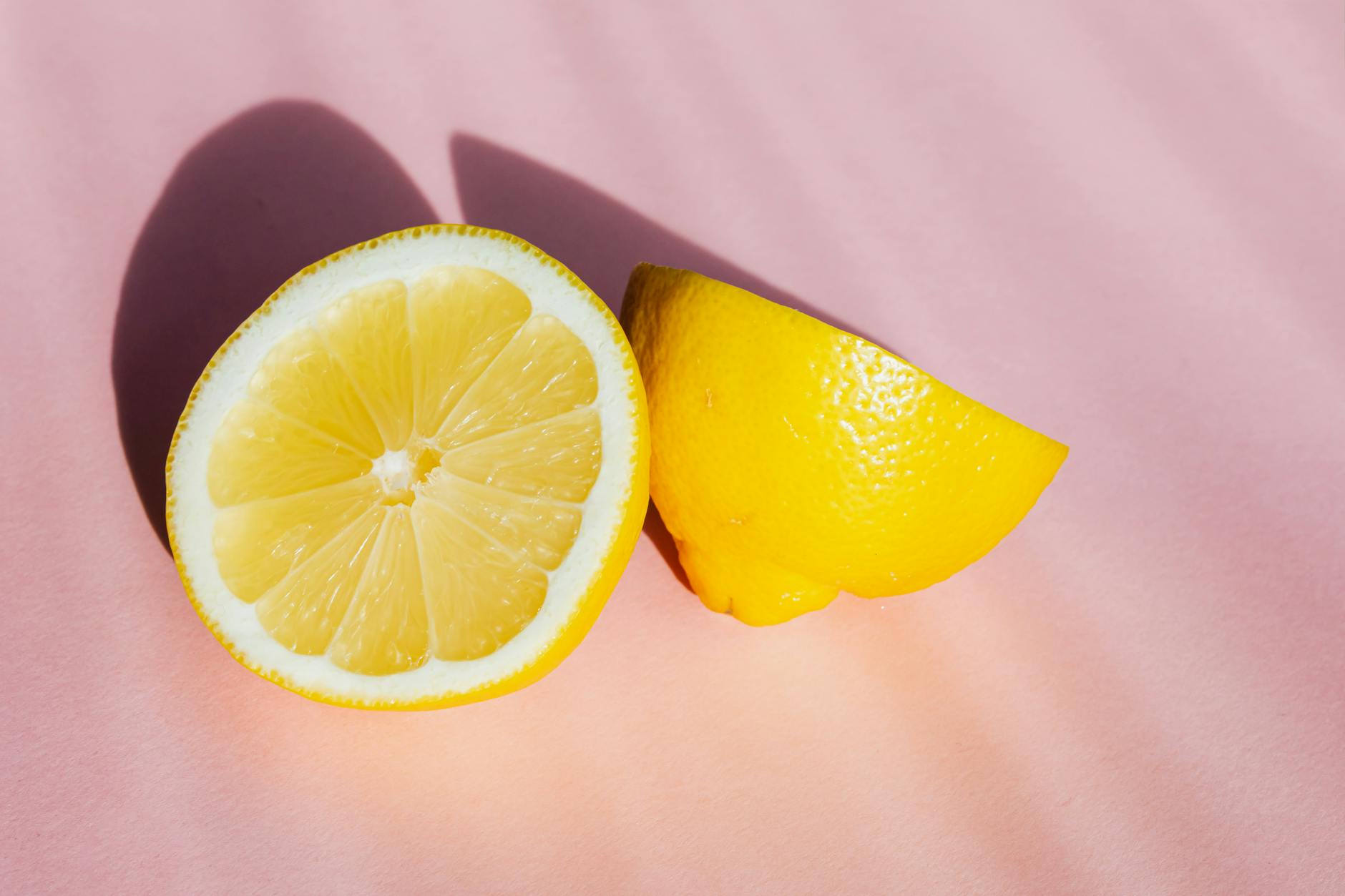 Vibrant ripe lemons arranged on a bright yellow background in studio lighting