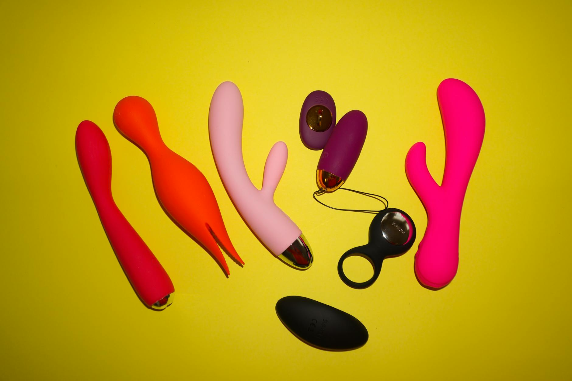 Yellow lemon vibrator surrounded by fresh bananas on a bright yellow background