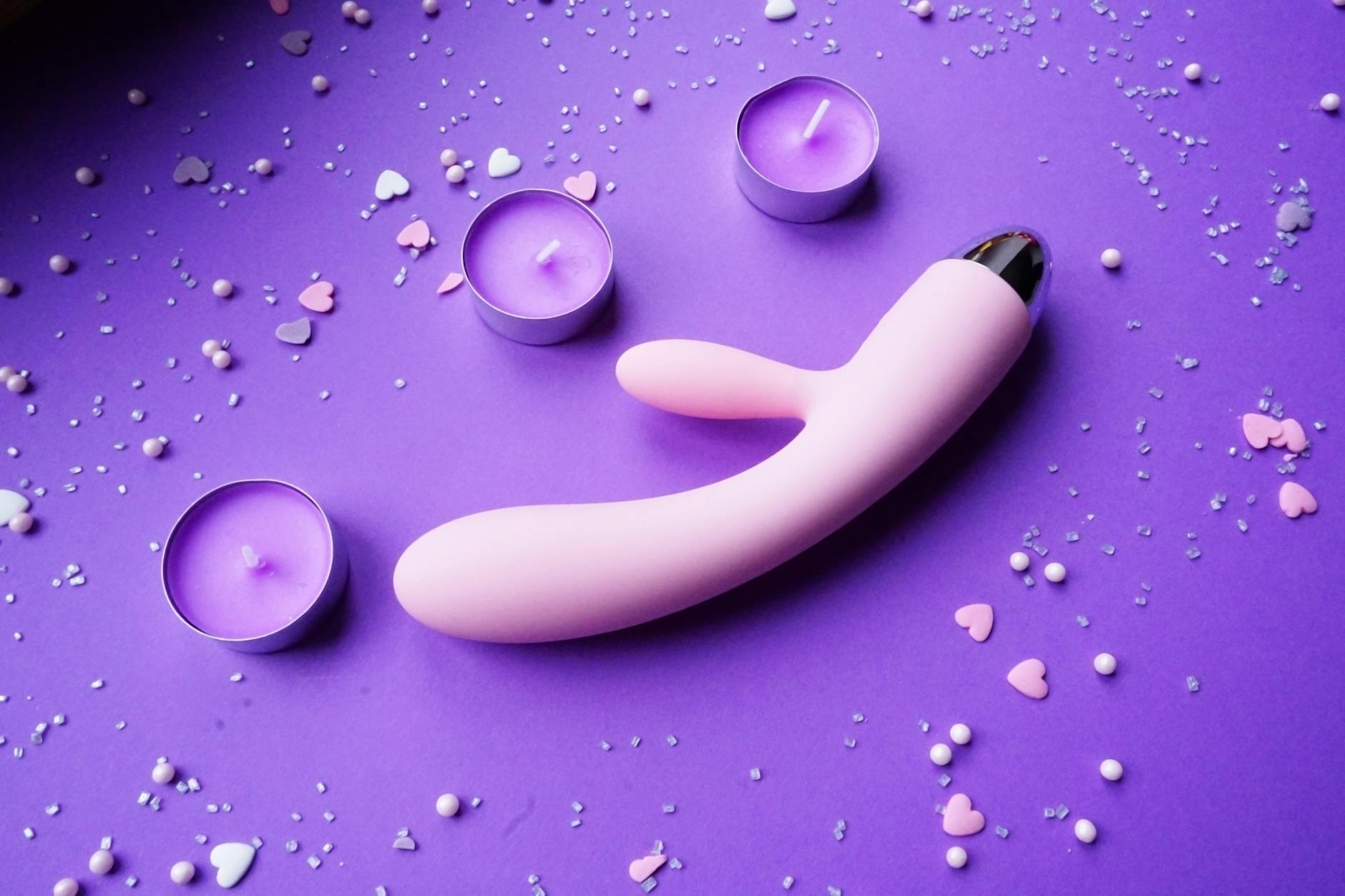 Pink lemon vibrator on a purple background with romantic ambient lighting